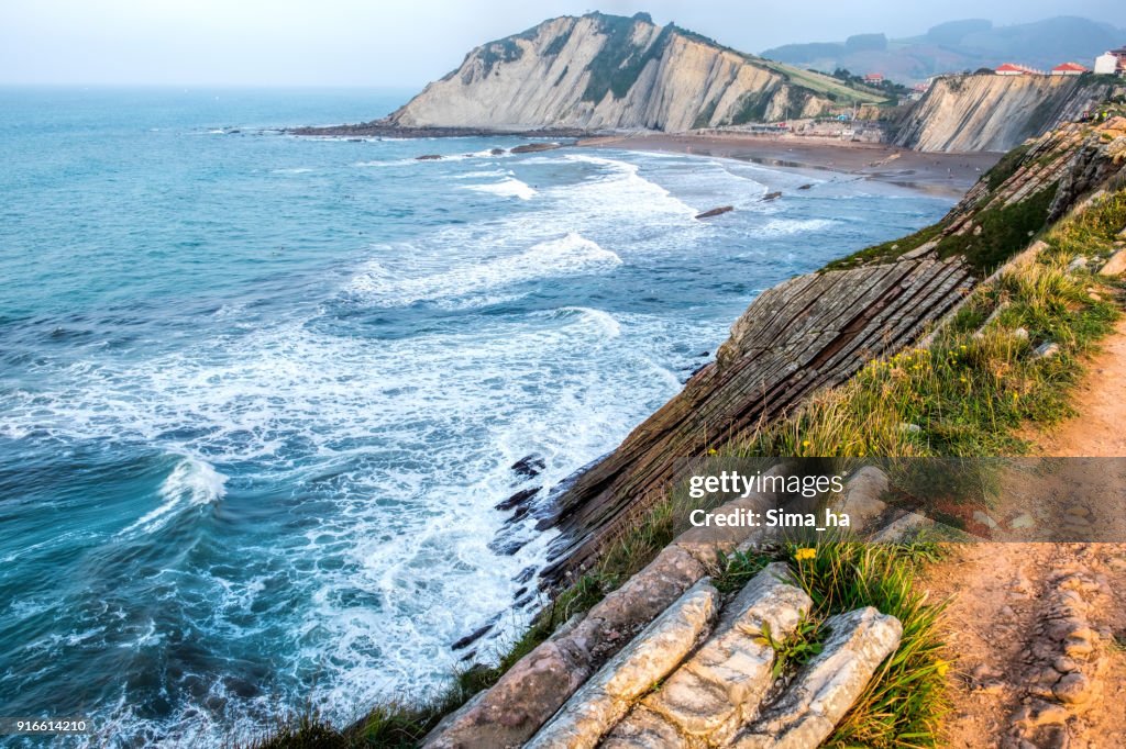 People walk on the Itzurun beach, Zumaya, Spain