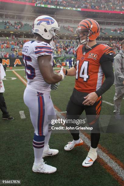 Jerry Hughes of the Buffalo Bills shares a moment at midfield with Andy Dalton of the Cincinnati Bengals during their game at Paul Brown Stadium on...