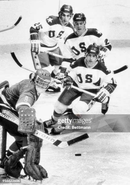 Norway's goalie Jim Martinsen fends off a shot on goal by American, Mark Pavelich as Mark Eruzione and Bill Schneider move up to help.