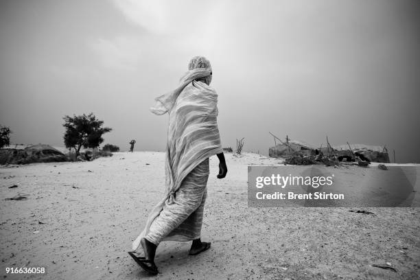 Songhai woman walks between temporary settlements on the outskirts of Timbuktu. Traders come from all over this region of Africa to do business in...