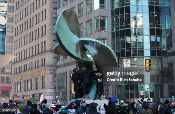 Fans climb a sculpture during the Philadelphia Eagles Super Bowl Victory Parade on February 8, 2018 in Philadelphia, Pennsylvania.