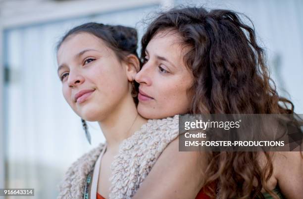 young mother are very close together with her teenager child - ponerse a cubierto fotografías e imágenes de stock