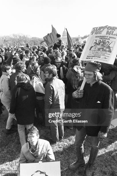 View of demonstrators, some with signs, gathered on the National Mall during the Moratorium March On Washington to protest the war in Vietnam,...