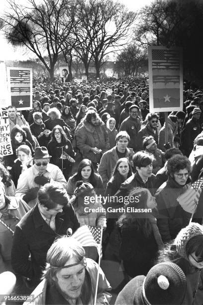 View of demonstrators, many with signs, banners, or flags, on an unspecified street during the Moratorium March On Washington to protest the war in...