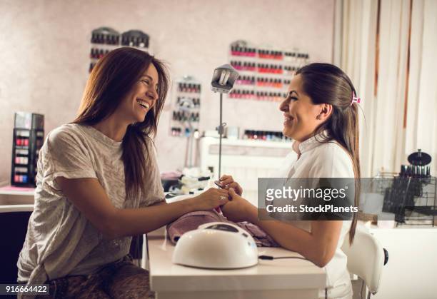 women enjoying manicure in beauty salon - manicure stock pictures, royalty-free photos & images