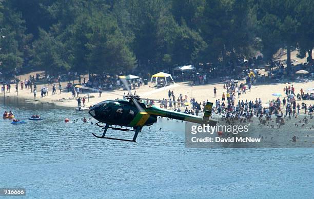 Los Angeles County Sheriff's helicopter flies past a crowed beach not far from the wreckage of a twin-engine airplane that crashed into a crowd of...