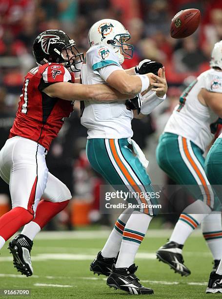 Chad Pennington of the Miami Dolphins has the ball knocked out of his hands by Kroy Biermann of the Atlanta Falcons at Georgia Dome on September 13,...