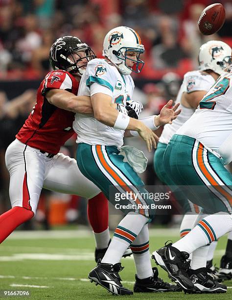 Chad Pennington of the Miami Dolphins has the ball knocked out of his hands by Kroy Biermann the Atlanta Falcons at Georgia Dome on September 13,...