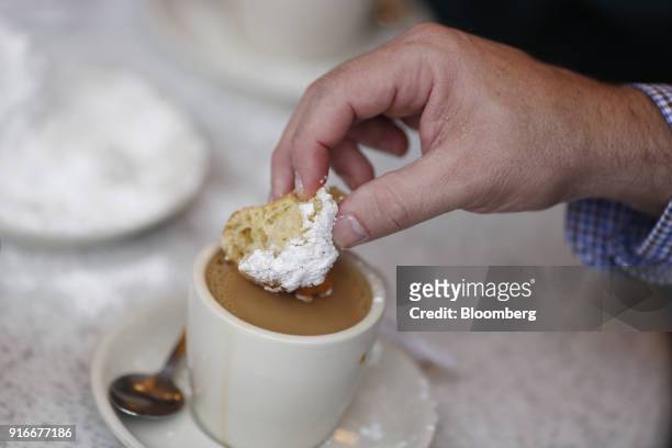 Customer eats a beignet at Cafe Du Monde in the French Quarter of New Orleans, Louisiana, U.S., on Wednesday, Feb. 7, 2018. New Orleans prepares for...
