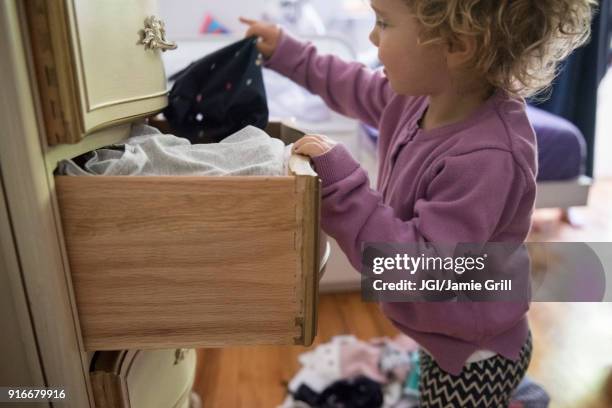 caucasian girl removing clothing from dresser drawer - drawer stock pictures, royalty-free photos & images