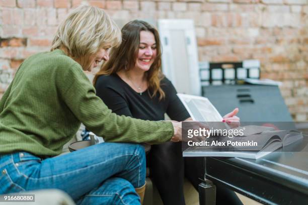 twee zakenvrouwen, 35 en 50 jaar oud, bespreking van sommige project in de moderne vrije stijl kantoor - 50 54 years stockfoto's en -beelden