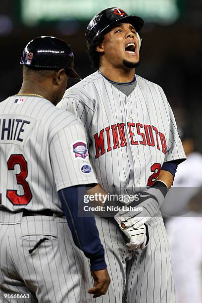 Carlos Gomez of the Minnesota Twins reacts after getting hit on the hand by a pitch against the New York Yankees in Game Two of the ALDS during the...