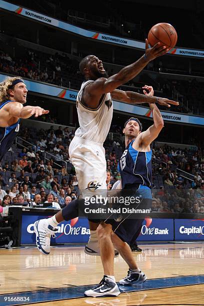 DeShawn Stevenson of the Washington Wizards shoots against Dirk Nowitzki Matt Carroll of the Dallas Mavericks at the Verizon Center during a...