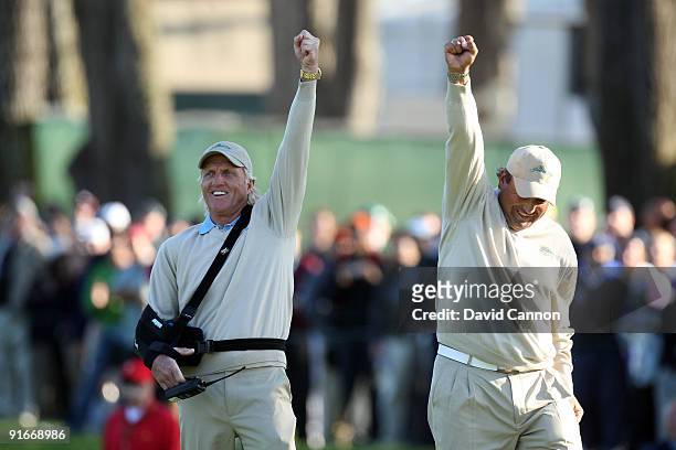 Greg Norman of Australia and the captain of the International Team celebrates with Angel Cabrera of Argentina as Tim Clark holes an eagle putt to win...