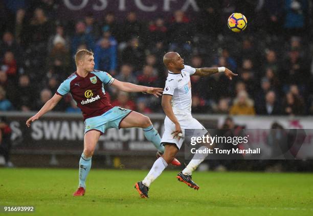 Andre Ayew of Swansea City is tackled by Ben Mee of Burnley during the Premier League match between Swansea City and Burnley at Liberty Stadium on...