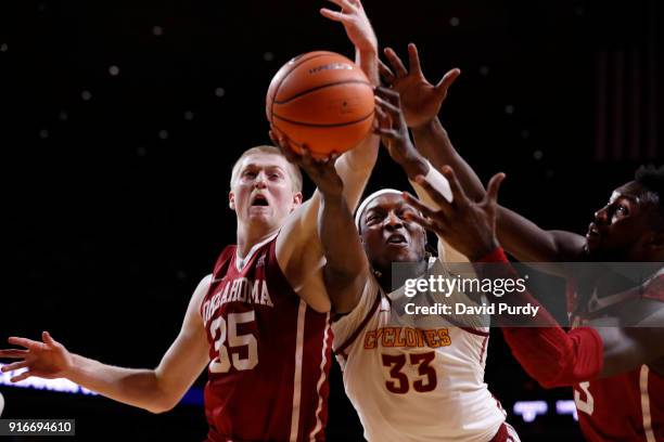 Solomon Young of the Iowa State Cyclones battles for a rebound with Brady Manek, and Khadeem Lattin of the Oklahoma Sooners in the second half of...