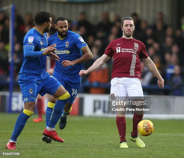 John-Joe O'Toole of Northampton Town looks to control the ball watched by Tom Soares and Liam Trotter of AFC Wimbledon during the Sky Bet League One...