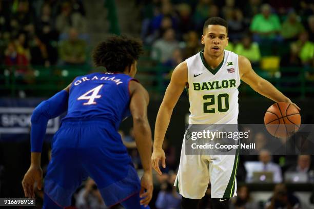 Manu Lecomte of the Baylor Bears brings the ball up court against Devonte' Graham of the Kansas Jayhawks during the first half at the Ferrell Center...