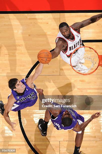 Greg Oden of the Portland Trail Blazers goes for the rebound against Omri Casspi and Jason Thompson of the Sacramento Kings during the preseason game...