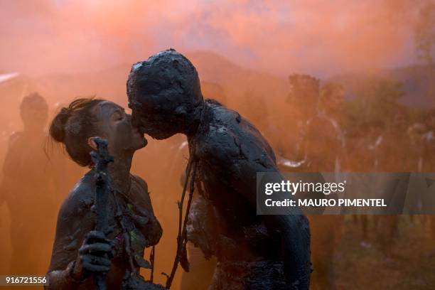 Revellers kiss during the "Bloco da Lama", a mud carnival, in Paraty, Brazil, on February 10, 2018. "Bloco da Lama" started in 1986 by teenagers...