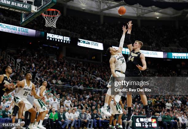 Isaac Haas of the Purdue Boilermakers shoots over Gavin Schilling of the Michigan State Spartans in the second half at Breslin Center on February 10,...