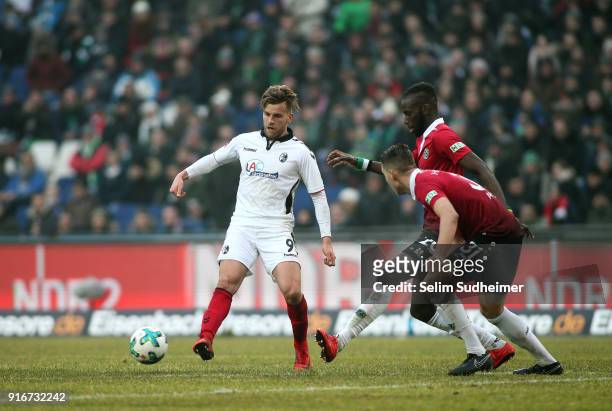 Lucas Hoeler of SC Freiburg fights for the ball with Salif Sane and Waldemar Anton of Hannover 96 during the Bundesliga match between Hannover 96 and...