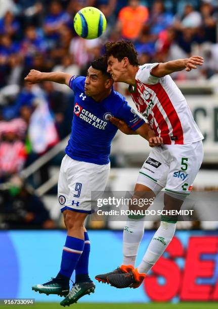 Cruz Azul's Felipe Mora jumps for the ball with Necaxa's Igor Lichnovsky during their Mexican Clausura 2018 tournament football match at the Azul...