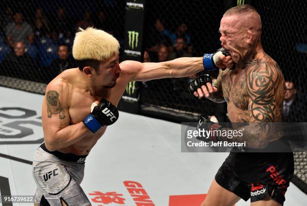 Mizuto Hirota of Japan punches Ross Pearson of England in their lightweight bout during the UFC 221 event at Perth Arena on February 11, 2018 in...