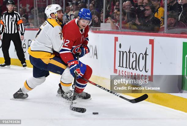 Byron Froese of the Montreal Canadiens skates with the puck under pressure from Yannick Weber of the Nashville Predators in the NHL game at the Bell...