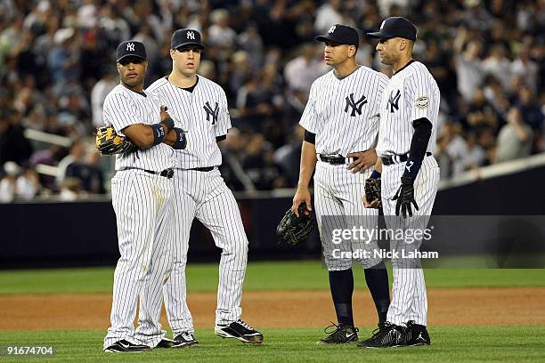 Robinson Cano, Mark Teixeira, Alex Rodriguez and Derek Jeter, of the New York Yankees look on during a pitching change while playing against the...