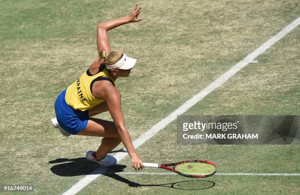 Ukraine's Marta Kostyuk stumbles while playing against Australia's Ashleigh Barty in their women's reverse singles Federation Cup tennis match in...
