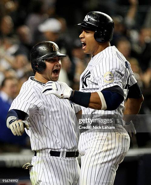 Alex Rodriguez of the New York Yankees celebrates with Nick Swisher after hitting a two run home run in the ninth inning against the Minnesota Twins...