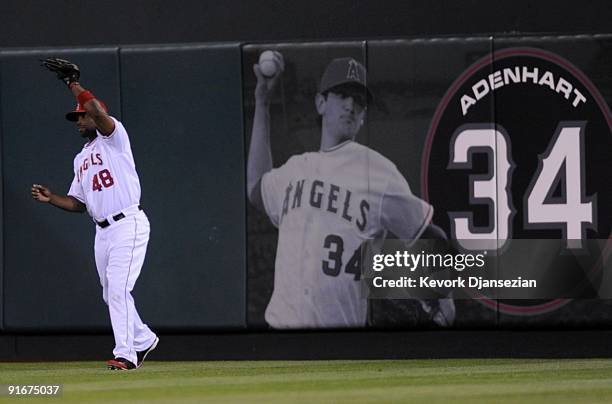 Torii Hunter of the Los Angeles Angels of Anaheim catches a fly ball hit by catcher Victor Martinez of the Boston Red Sox in front of a sign...