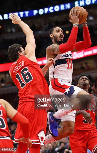 Mike Scott of the Washington Wizards drives between Paul Zipser and Bobby Portis of the Chicago Bulls at the United Center on February 10, 2018 in...