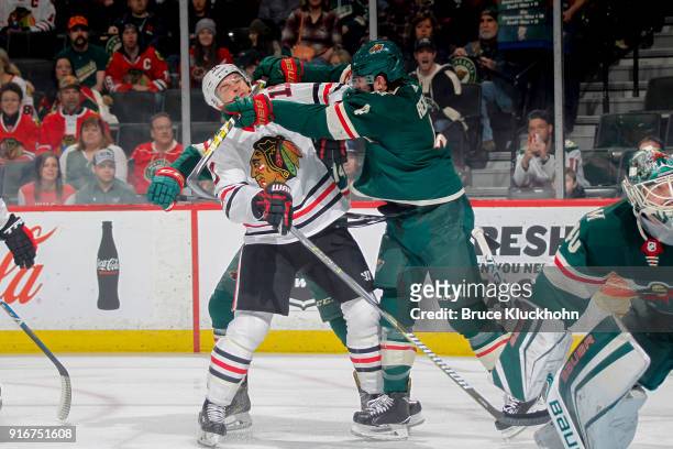 Mike Reilly of the Minnesota Wild cross checks Lance Bouma of the Chicago Blackhawks during the game at the Xcel Energy Center on February 10, 2018...