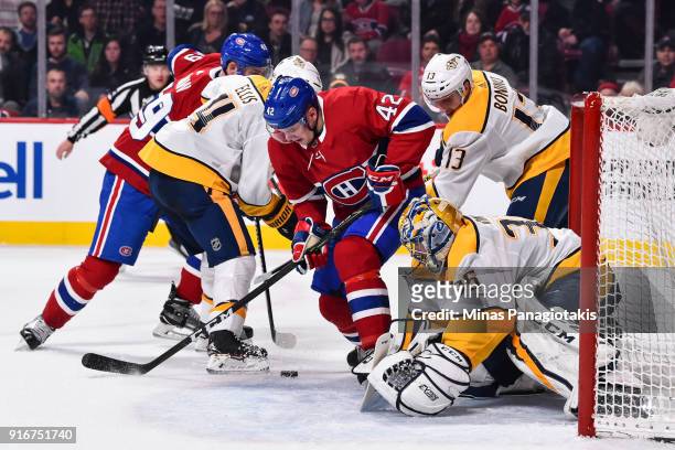 Goaltender Pekka Rinne of the Nashville Predators defends his net as teammate Nick Bonino challenges Byron Froese of the Montreal Canadiens during...