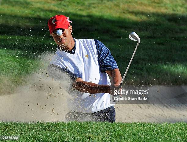 Tiger Woods chips out of the bunker onto the 14th green the during the second round four-ball matches for The Presidents Cup at Harding Park Golf...