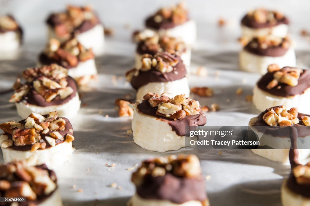 Banana slices covered with chocolate and nuts