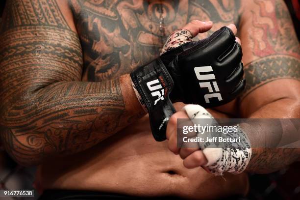 Mark Hunt of New Zealand takes off his gloves after facing Curtis Blaydes in their heavyweight bout during the UFC 221 event at Perth Arena on...