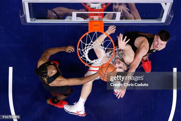 Nick Rakocevic and Elijah Stewart of the USC Trojans fight for a rebound with Dusan Ristic of the Arizona Wildcats during the first half of the...