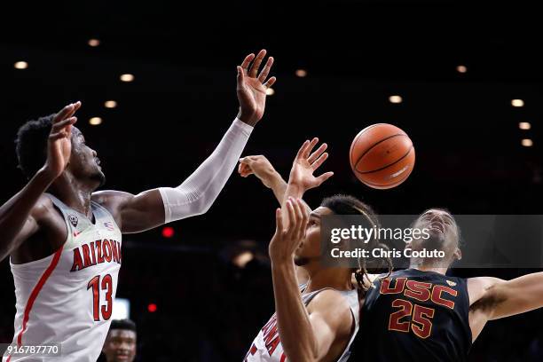 Deandre Ayton and Keanu Pinder of the Arizona Wildcats fight for a rebound with Bennie Boatwright of the USC Trojans during the second half of the...