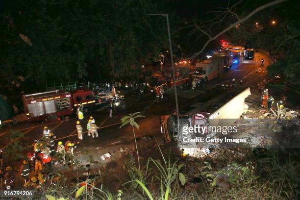Rescuers work at the accident site where a double-decker bus overturns to its left on Tai Po Road on February 10, 2018 in Hong Kong, China. At least...