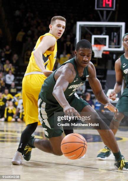 Forward Jaren Jackson of the Michigan State Spartans scrambles for a loose ball during the first half in front of guard Jordan Bohannon of the Iowa...