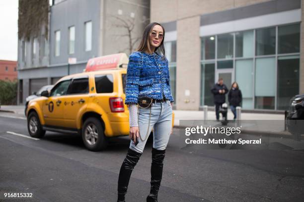 Chriselle Lim is seen on the street attending Self-Portrait during New York Fashion Week wearing a blue fringe coat with faded demin jeans and black...