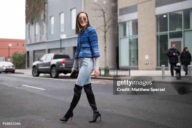 Chriselle Lim is seen on the street attending Self-Portrait during New York Fashion Week wearing a blue fringe coat with faded demin jeans and black...