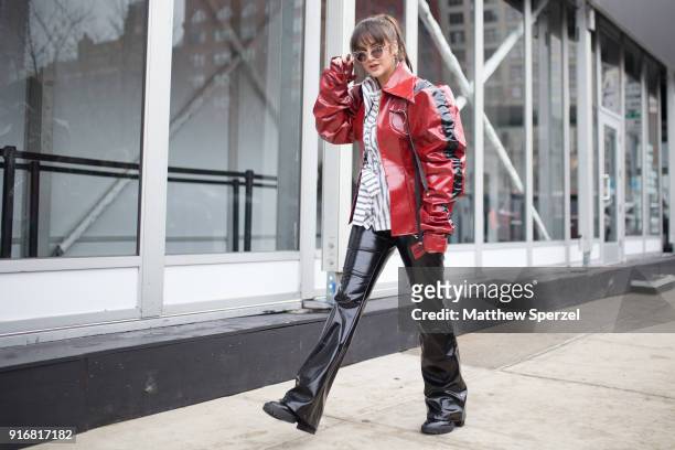 Guest is seen on the street attending Taoray Wang during New York Fashion Week wearing a vinyl red jacket on February 10, 2018 in New York City.