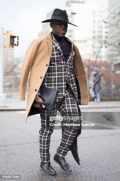 Guest is seen on the street attending Taoray Wang during New York Fashion Week wearing a camel coat with plaid suit and black cowboy hat on February...