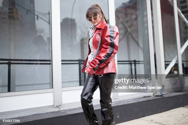 Guest is seen on the street attending Taoray Wang during New York Fashion Week wearing a vinyl red jacket on February 10, 2018 in New York City.