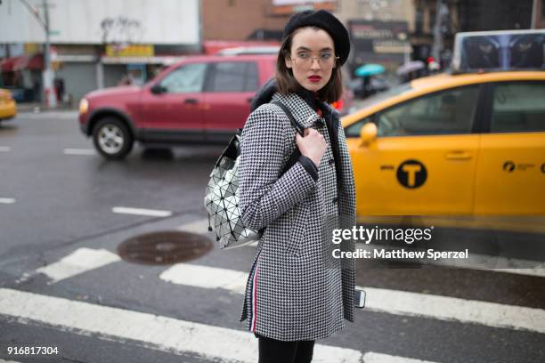 Guest is seen on the street attending Taoray Wang during New York Fashion Week wearing a black/white houndstooth jacket with black beret on February...