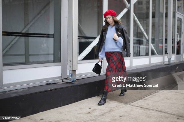 Guest is seen on the street attending Taoray Wang during New York Fashion Week wearing a red plaid skirt with blue sweater and black leather jacket...